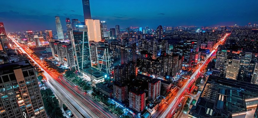 Beijing skyline with Forbidden City rooftops and CCTV tower behind imperial pavilions