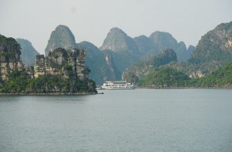 Traditional boat sailing through limestone karst islands of Halong Bay, Vietnam