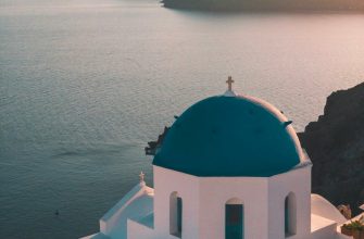 White-and-blue caldera houses in Oia, Santorini, with the Aegean Sea below