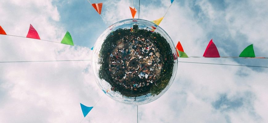 Festival disco ball with colorful pennant flags against cloudy sky representing Breckenridge year-round events