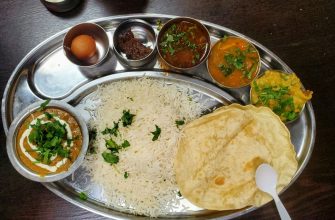 Steel thali with rice, dal, sabzi and chutneys