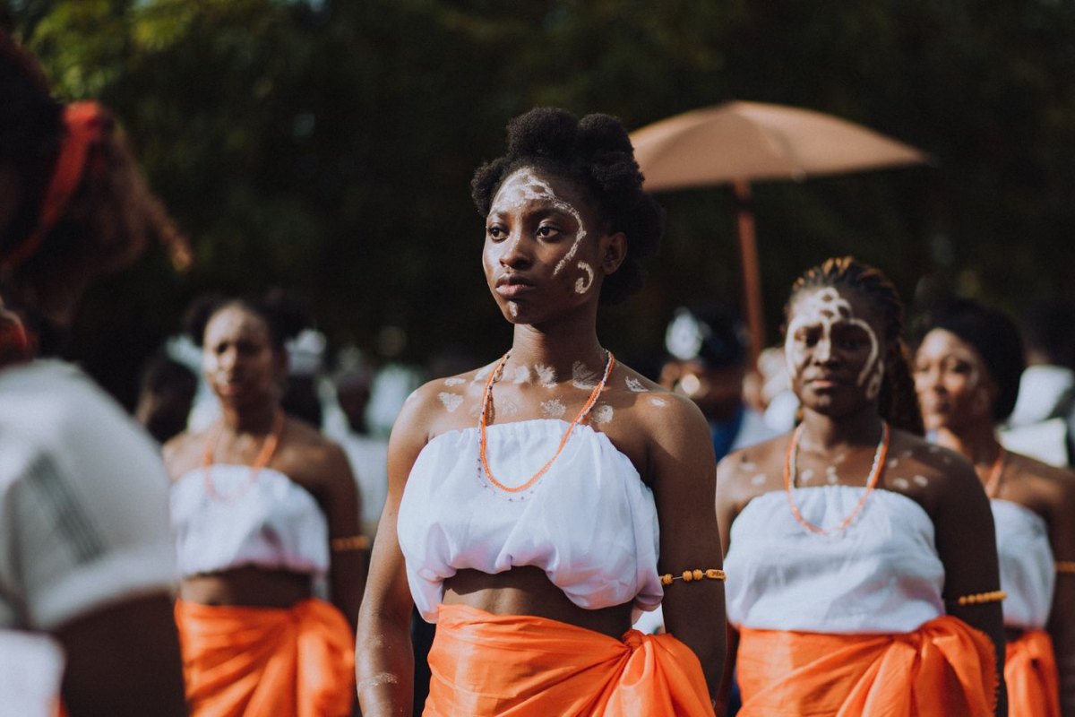 Young women in white and orange at a traditional African ceremony