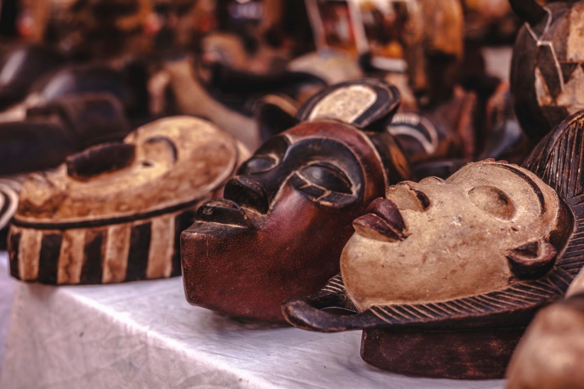 A row of carved wooden African masks on a market stall
