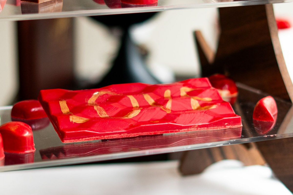 A tiered display of handmade artisan chocolates and a decorated chocolate bar