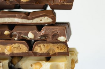 A stack of dark, milk and white chocolate bars with nuts and fillings