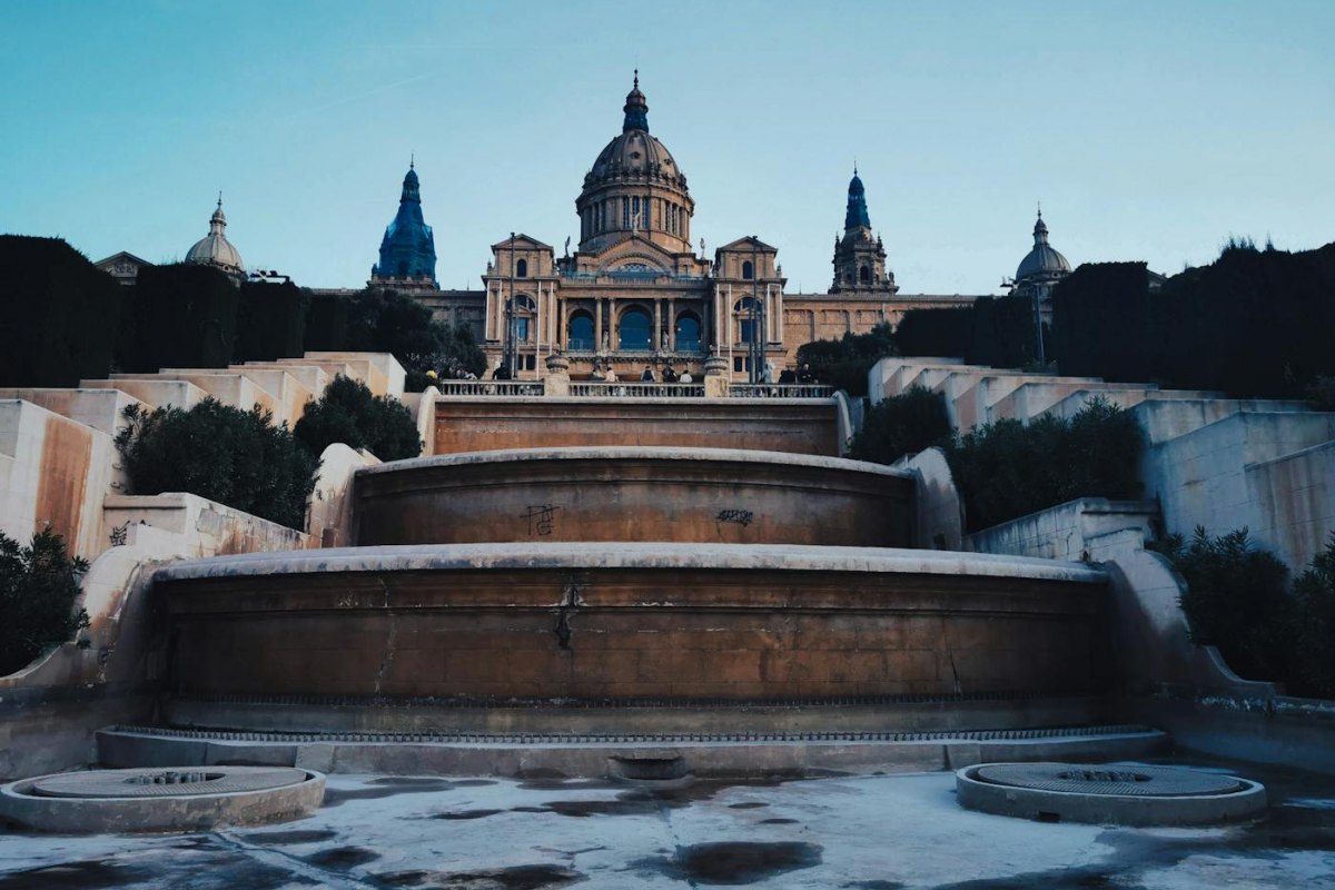 The domed Palau Nacional on Montjuic at dusk above its terraced fountains