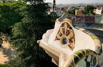 The serpentine trencadis mosaic bench at Park Guell above the Barcelona skyline