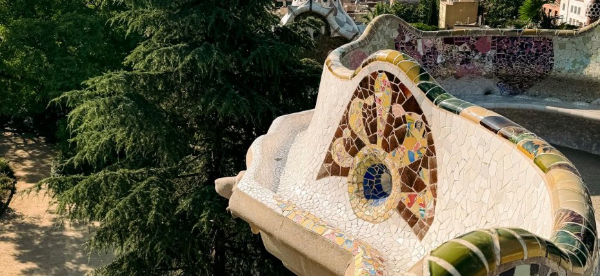 The serpentine trencadis mosaic bench at Park Guell above the Barcelona skyline