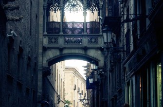 A narrow medieval Gothic street with a carved stone bridge in Barcelona old town