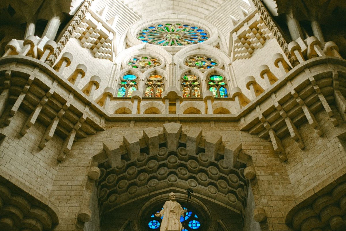 Coloured light from stained-glass windows filling the nave of the Sagrada Familia