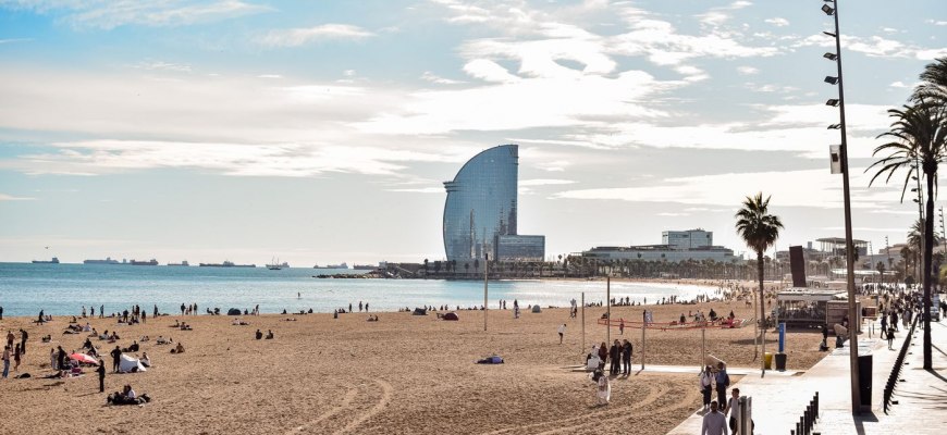 Barceloneta beach with the palm-lined promenade and the sail-shaped W hotel beyond