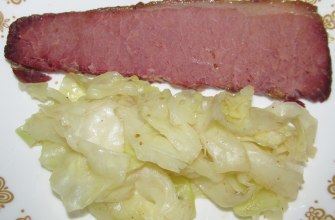 A plate of corned beef with cabbage and potato