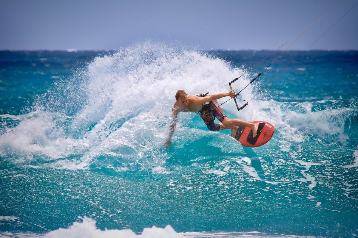 A kitesurfer carving a turn in the blue water off Corralejo