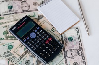 A calculator and notepad on banknotes used to budget the cost of living abroad