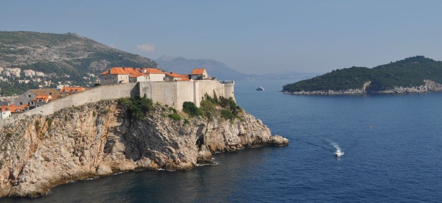The old town walls of Dubrovnik on the cliffs above the blue Adriatic Sea