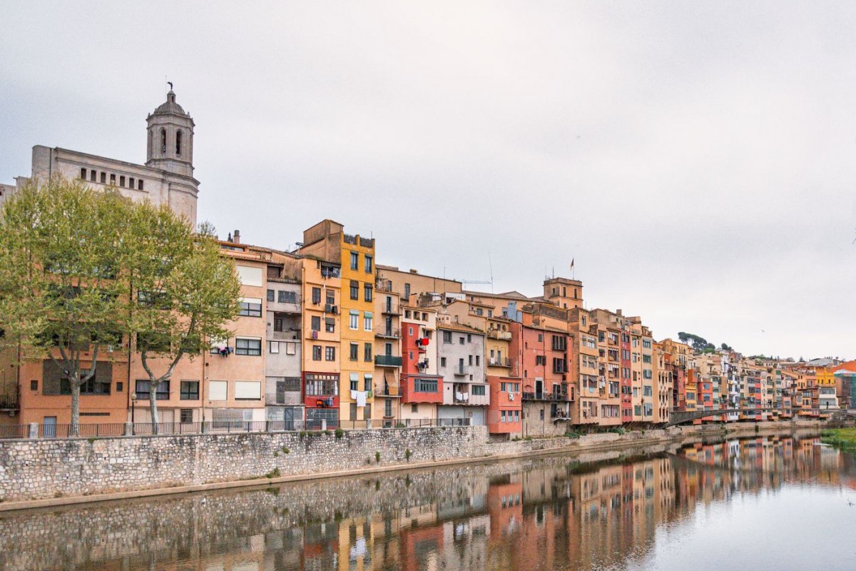 The colourful houses and cathedral of Girona reflected in the Onyar river