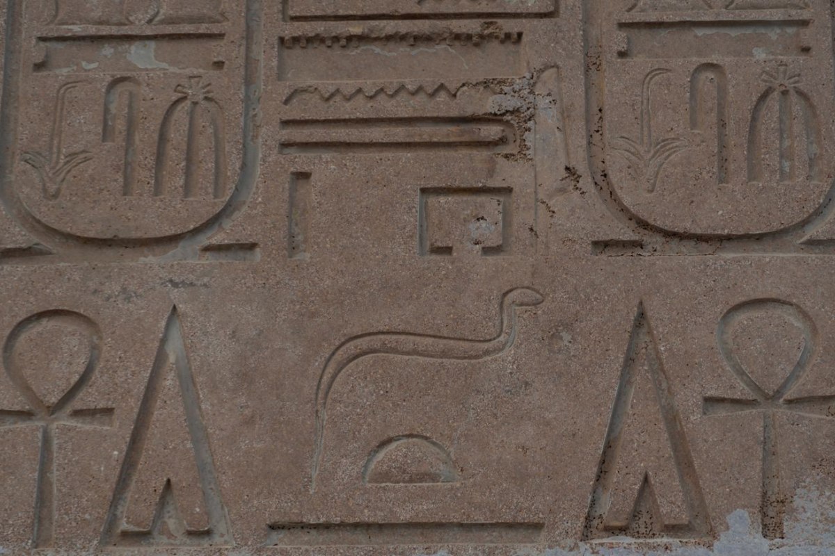 Ancient Egyptian hieroglyphs carved into a sandstone wall