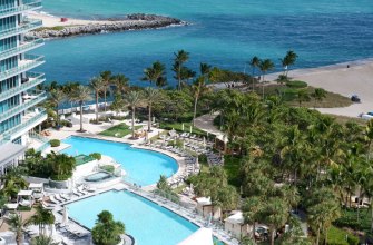 Aerial view of a Florida beachfront resort with two pools, palm trees and the ocean