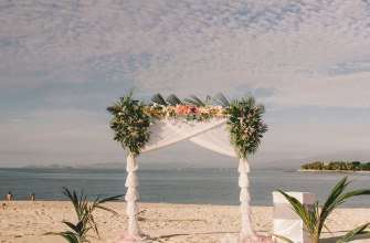 A floral wedding arch on a beach by the sea