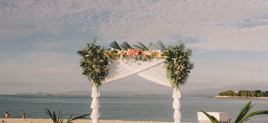 A floral wedding arch on a beach by the sea