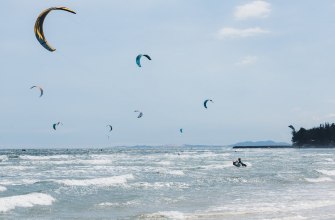 Kitesurfers riding waves under a clear sky