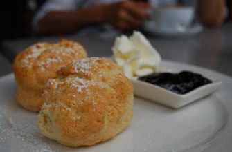 Scones split and spread with jam and whipped cream