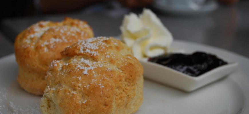 Scones split and spread with jam and whipped cream