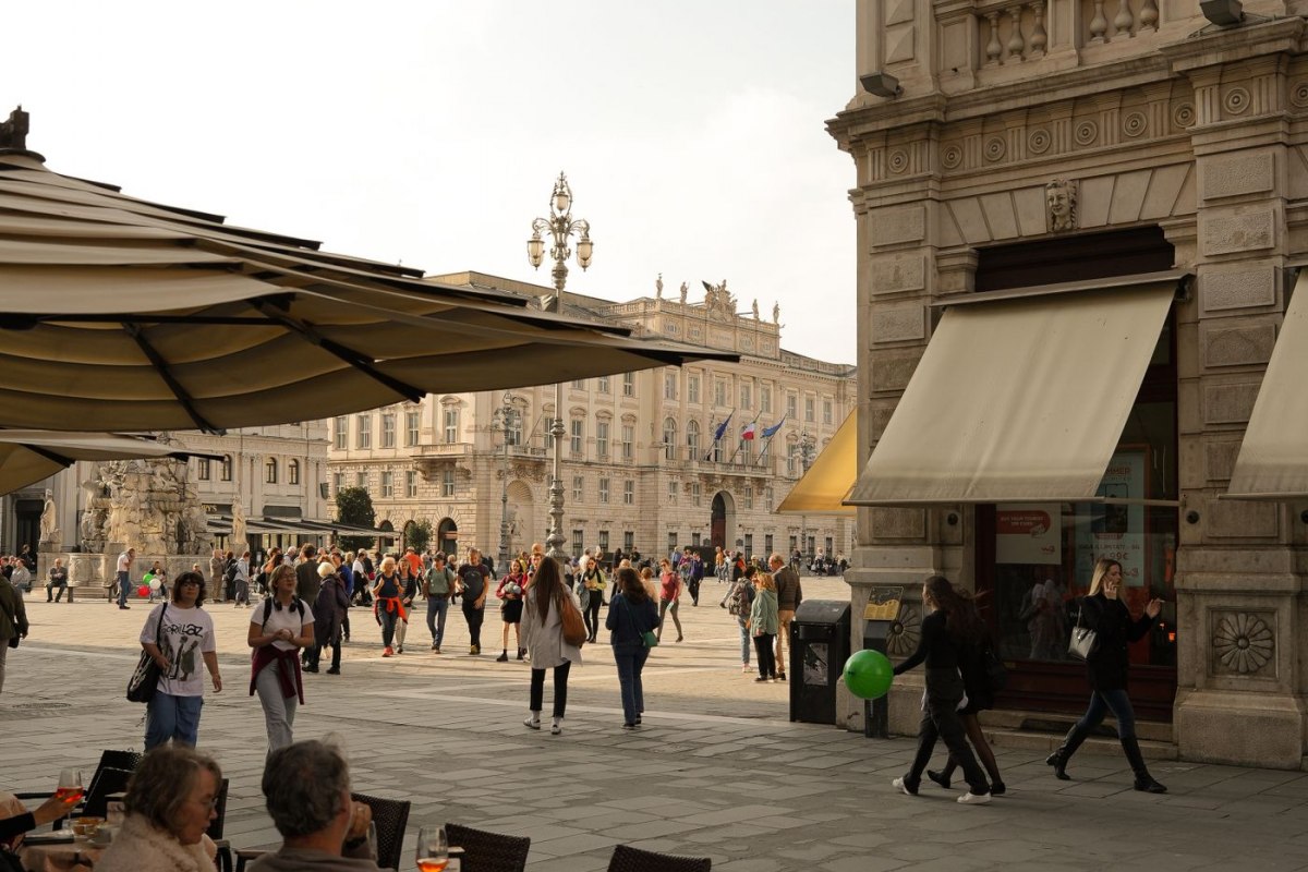 People socialising at an outdoor cafe terrace on an Italian square