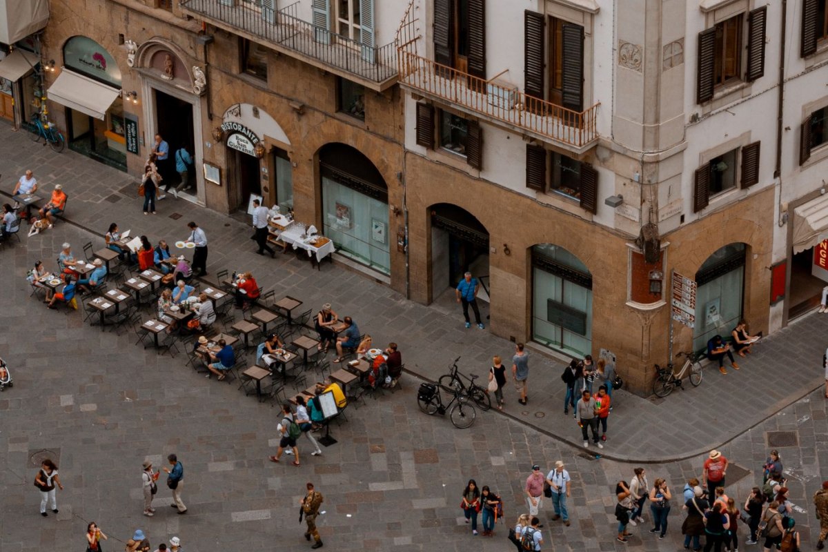 A busy square in Florence surrounded by Renaissance architecture