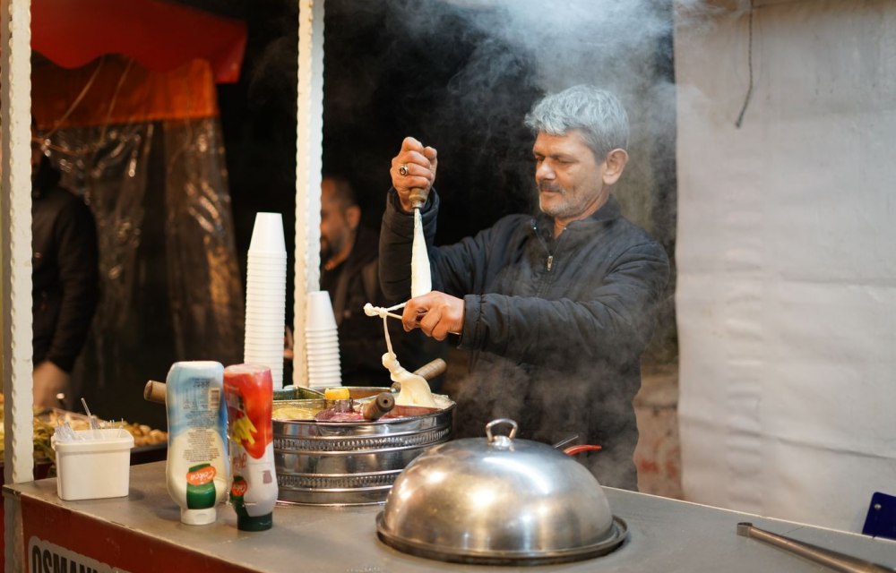 A vendor stretching Turkish Maras ice cream on a paddle