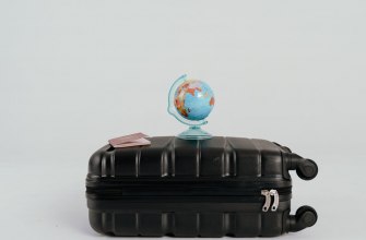 A globe resting on a packed suitcase ready for a move abroad