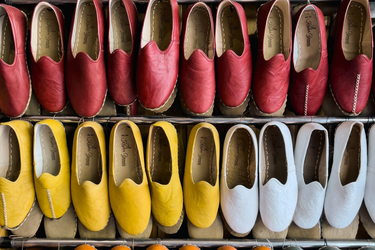 Assorted colourful espadrille shoes arranged on a shop shelf