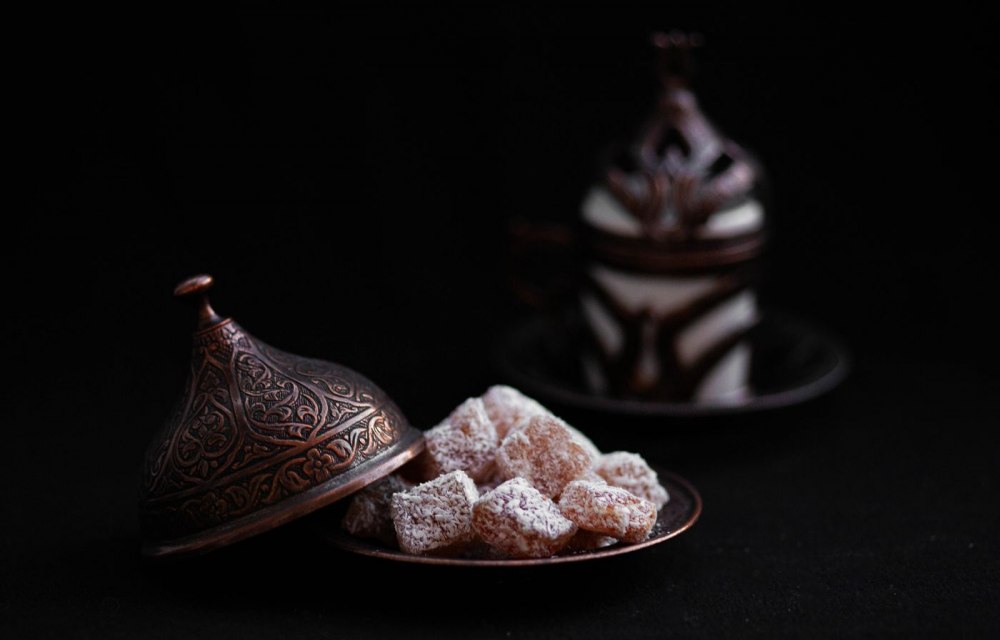 Turkish delight on a copper plate beside a cup of Turkish coffee